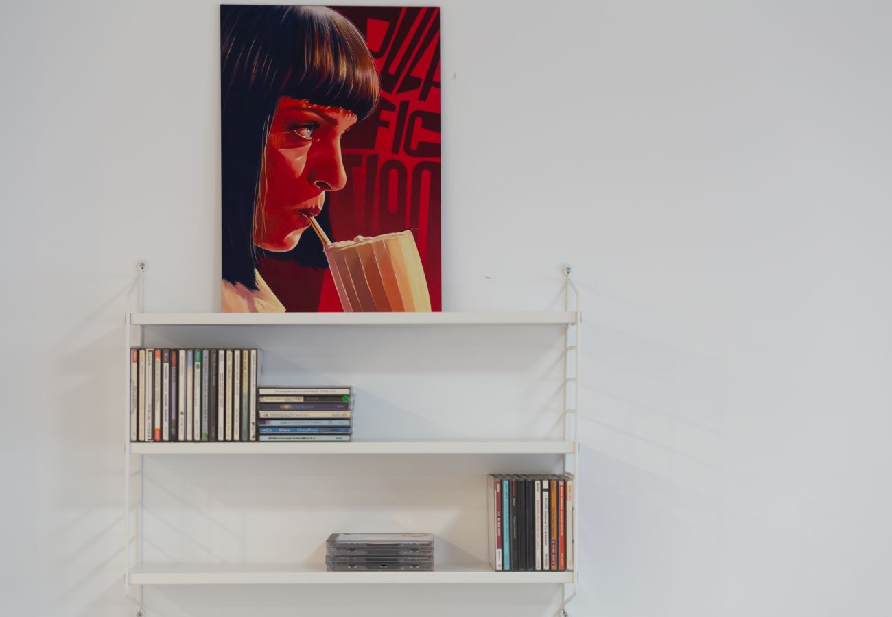 Estantería de CD con póster Uma Thurman como Mia Wallace en apartamento de 1 dormitorio en el centro de Málaga